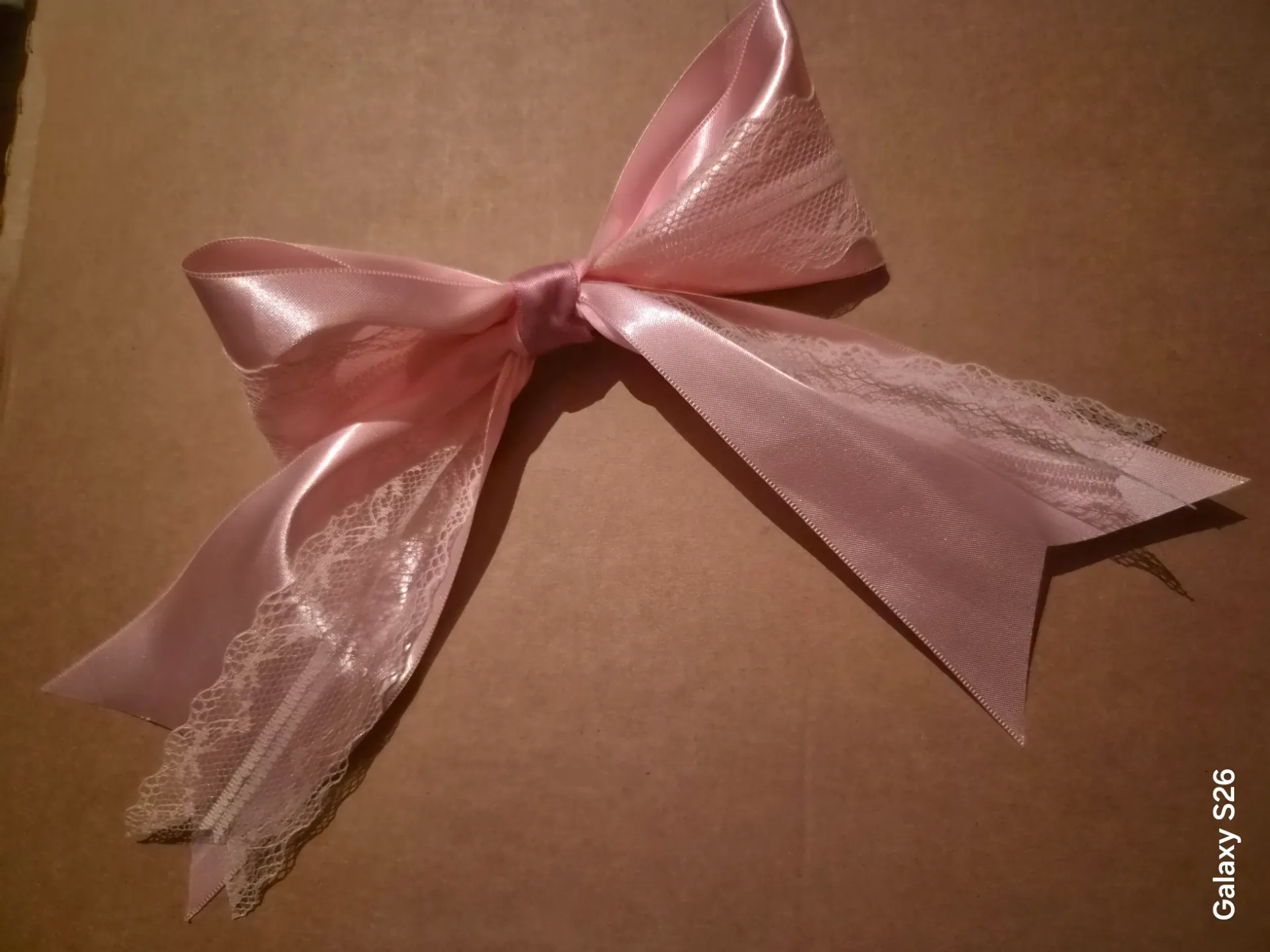 Grote roze strik met kant op speld